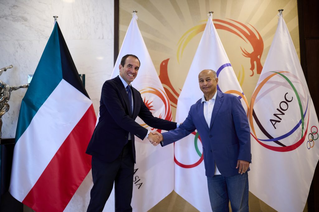 Officials from the International Padel Federation and the Olympic Council of Asia shaking hands in front of OCA and ANOC flags, formally confirming padel as a medal sport at the 2026 Asian Games.