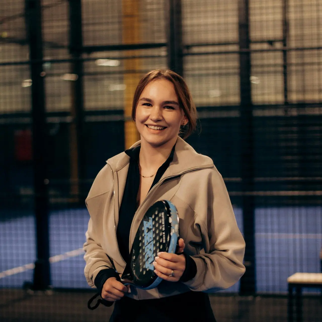 Players reading the Sunday Drop on a padel court bench.