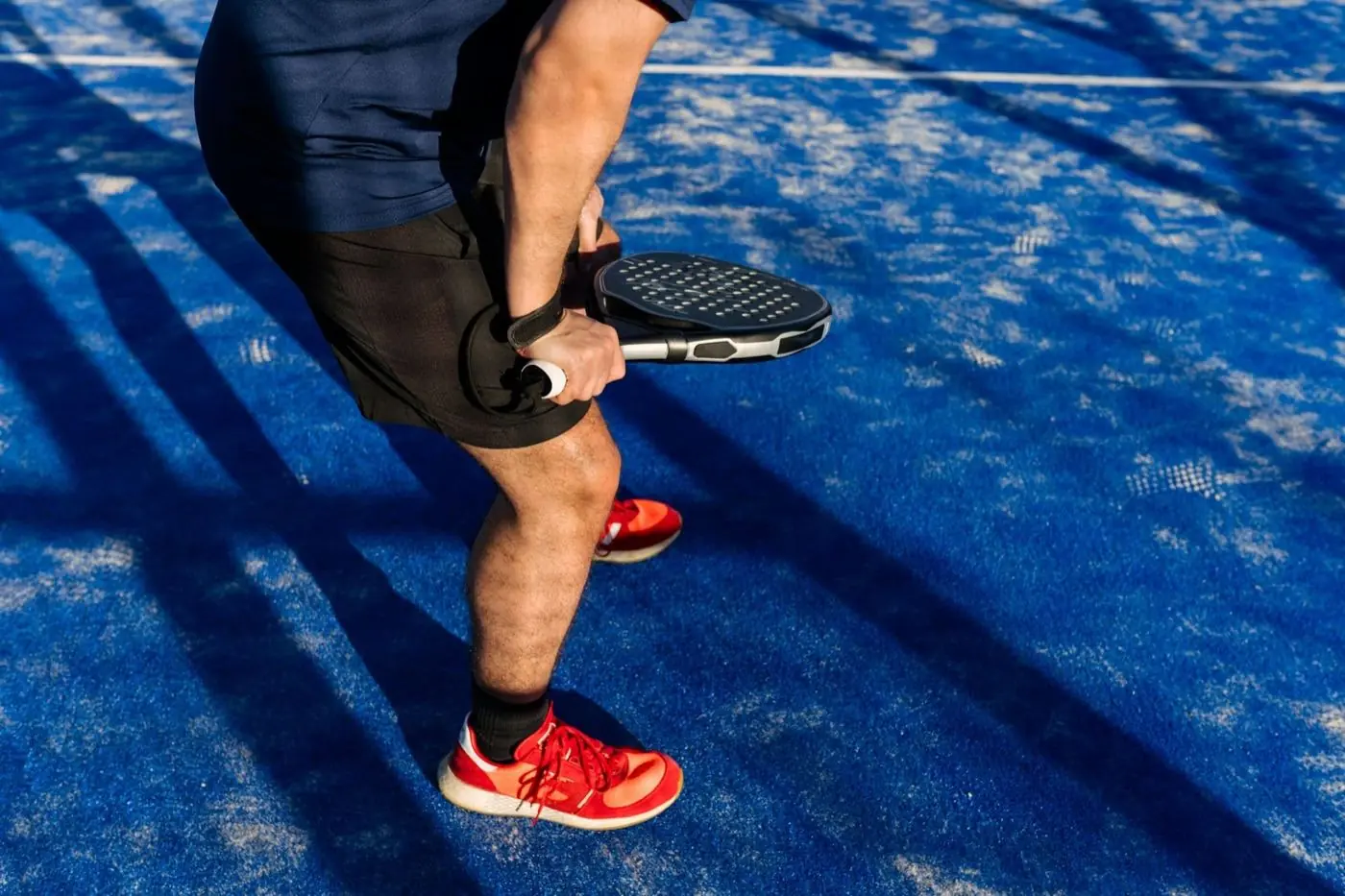 Padel player about to hit the ball on a blue court