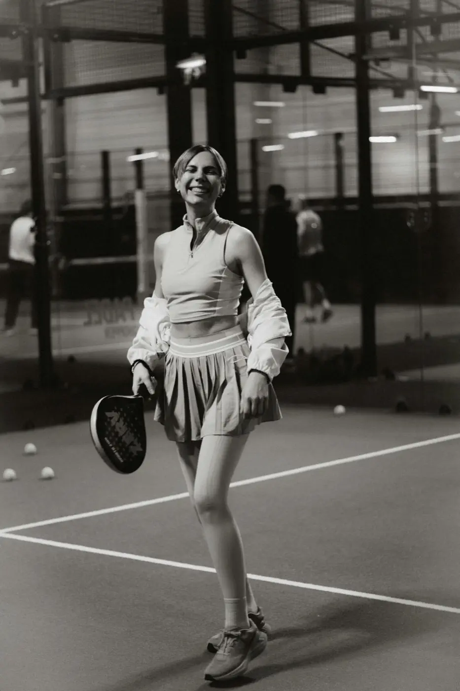 Padel player smiling on an indoor court