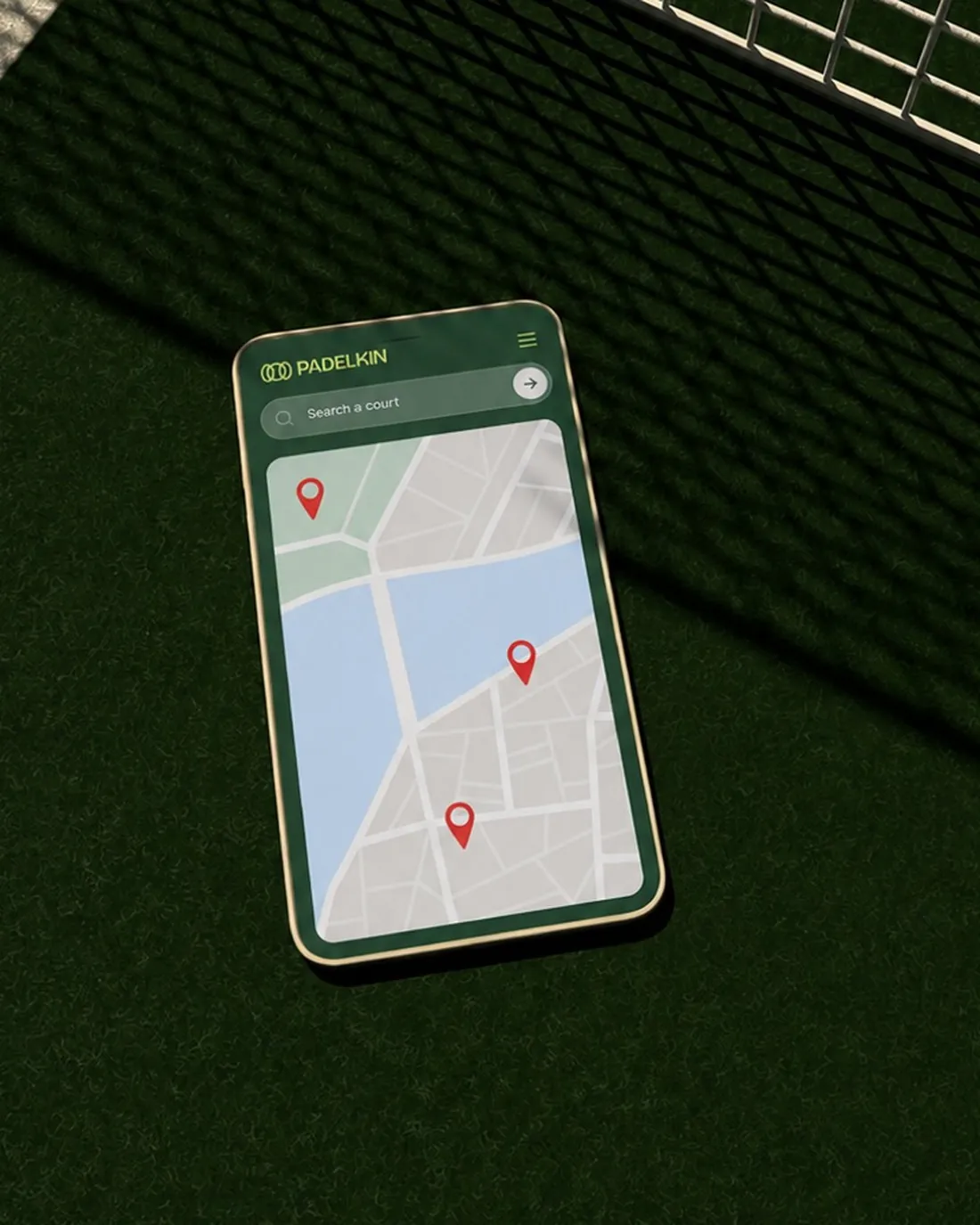 A phone on a padel court showing the Padelkin courts app with map pins.